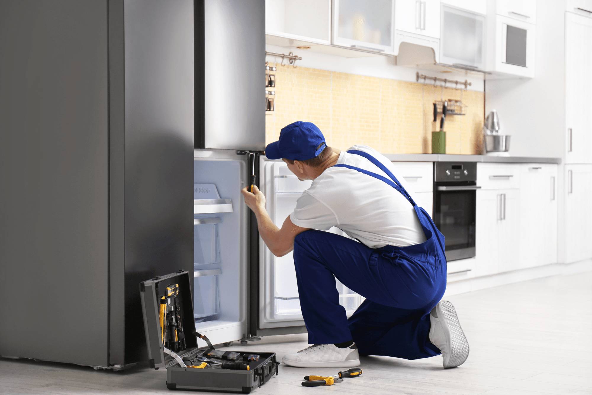 Professional refrigerator technician with toolbox ready to repair your refrigerator